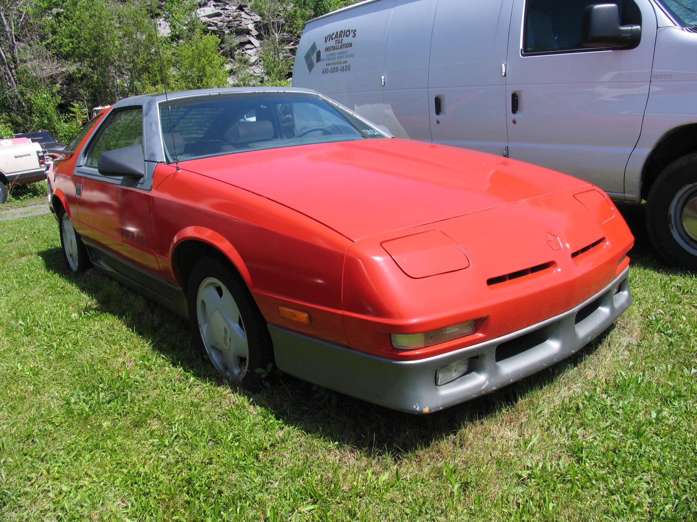 an orange sports car is parked next to another one