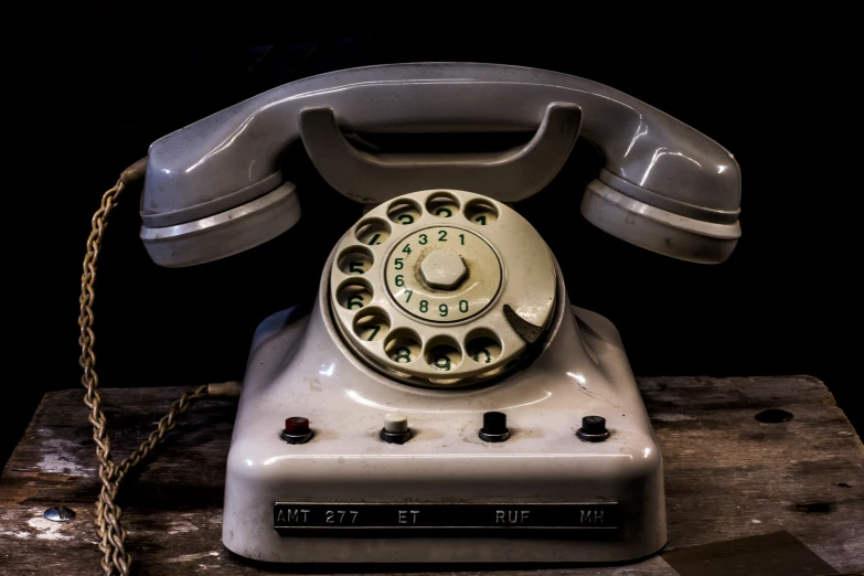 an old fashioned, portable telephone has a chain