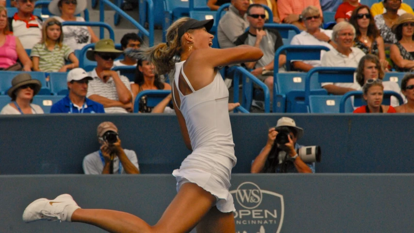 a lady tennis player swinging her racquet towards the crowd