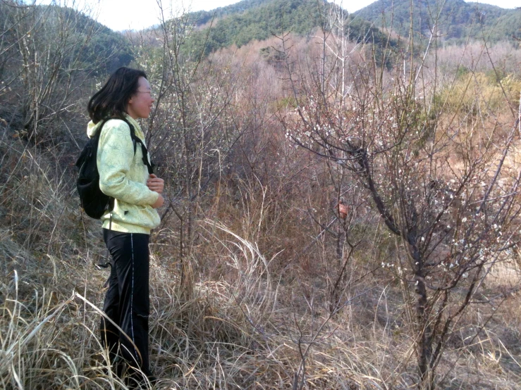 a young woman standing alone in tall brush