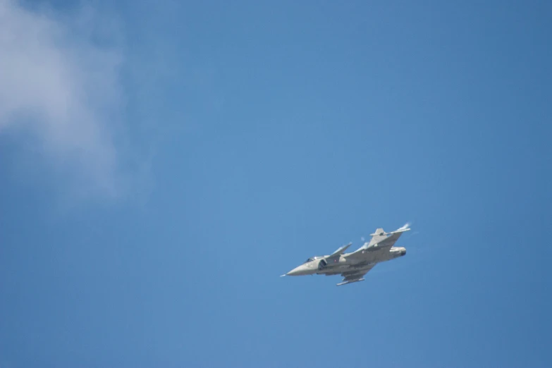 two jets fly against the blue sky with clouds