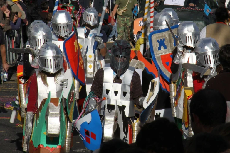 a large group of knight's in full armor walking along a road