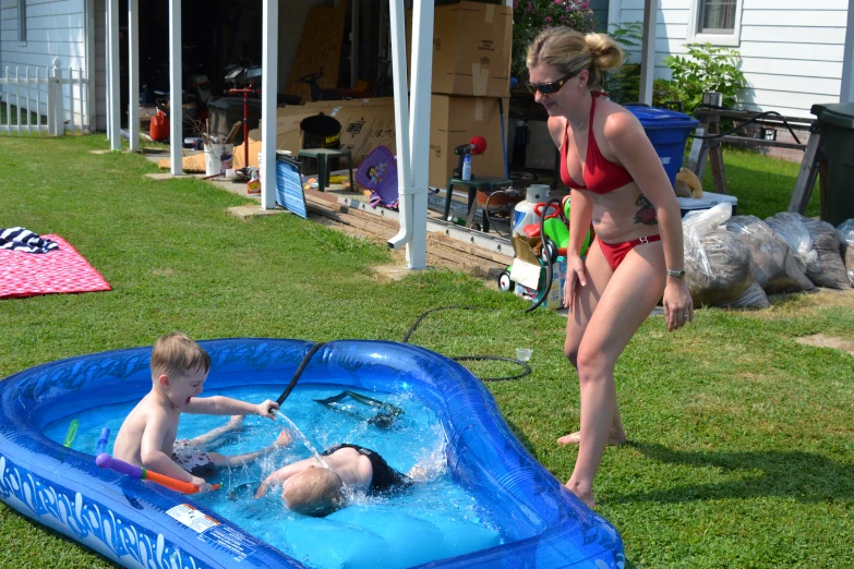 a mother and child playing in an intet pool on the grass