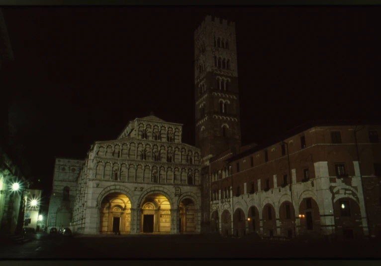 an illuminated old building with a tower at night