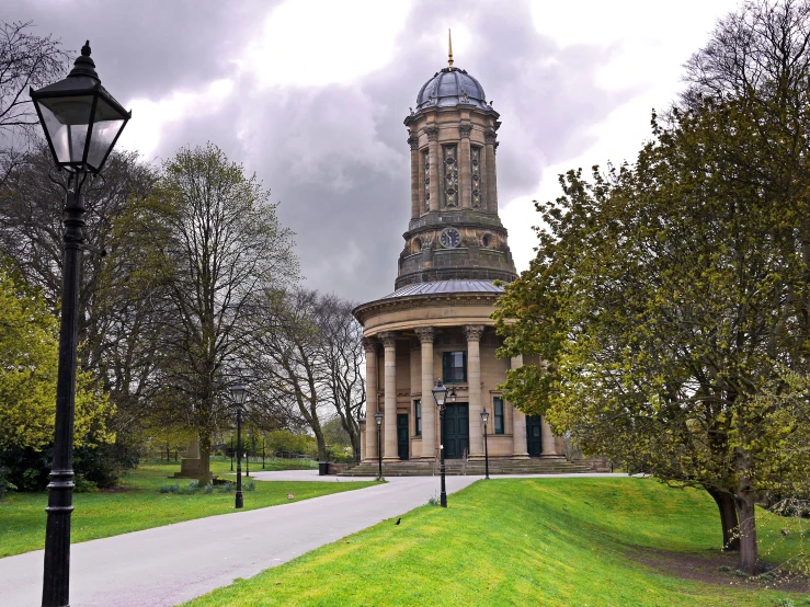 a large clock tower stands in the middle of the park