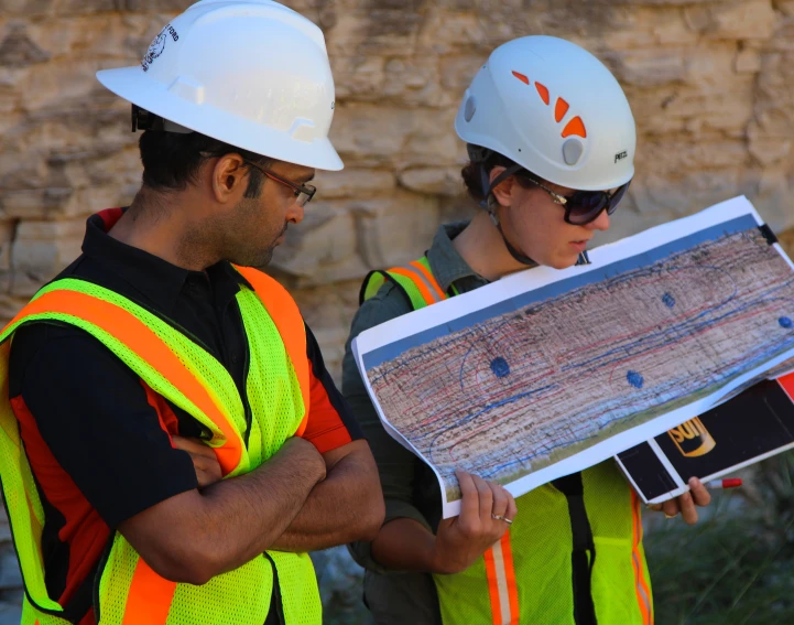 a pair of construction workers holding a map