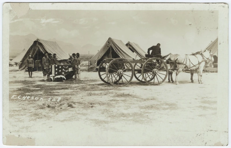 two people and a wagon with tents in the background