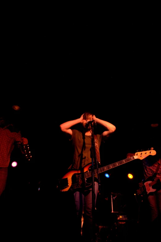 woman covering her face with her hands while standing on stage