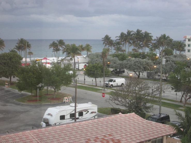 view of a street with parked trucks and palm trees