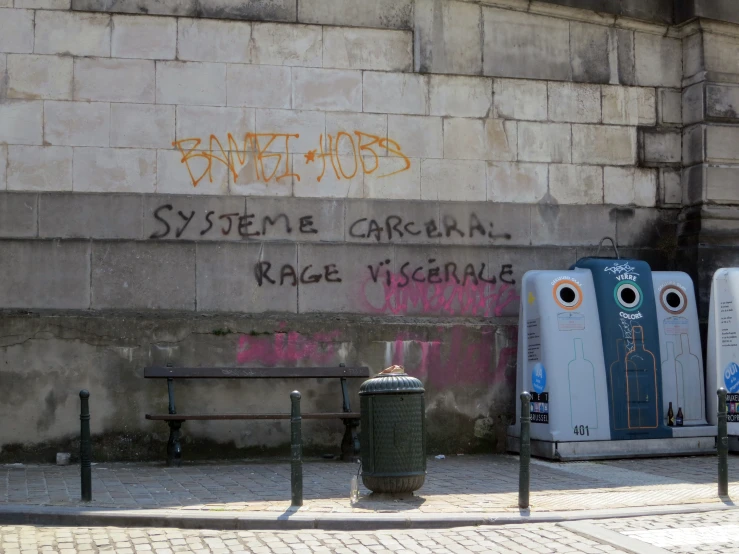 there are three graffiti painted signs and a bench