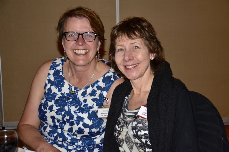 two women sitting and smiling for the camera