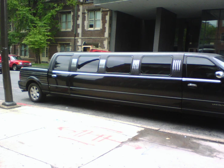 the black stretch limo is parked in front of a el