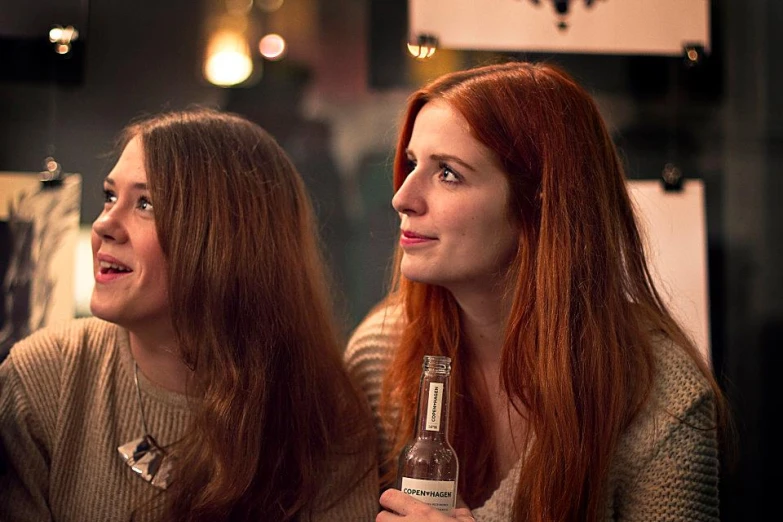 two women standing side by side and looking off in the distance