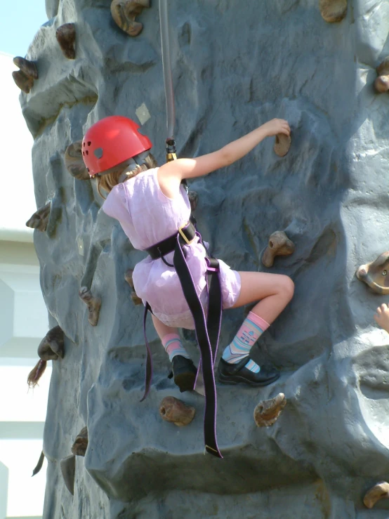 a girl is climbing up a rock wall