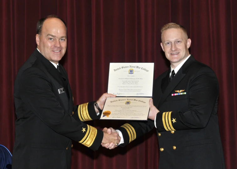 two military men in formal dress clothing are shaking hands