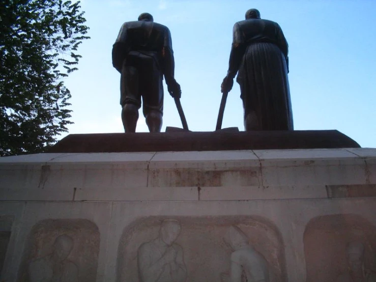 two statues that are on top of a structure