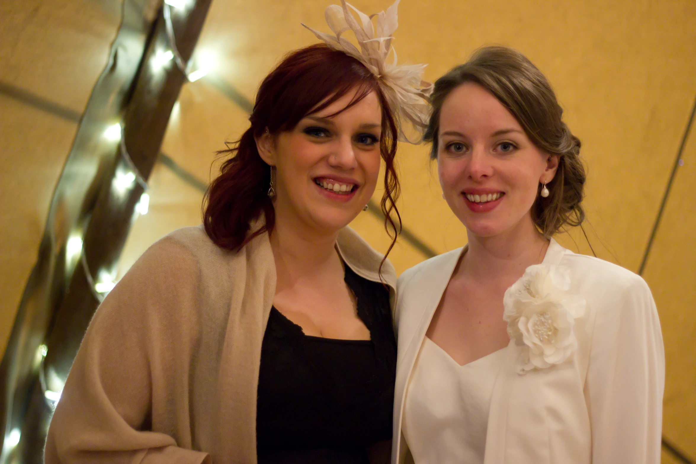 two women smiling for the camera and dressed in formal clothes