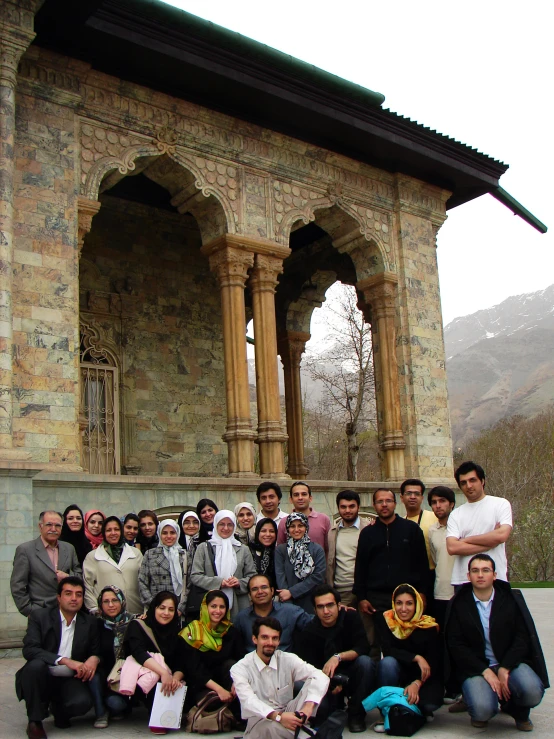 group of people standing and sitting next to each other