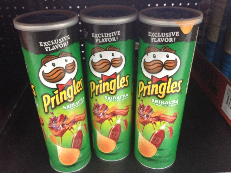 three pringles in cans are sitting on a shelf