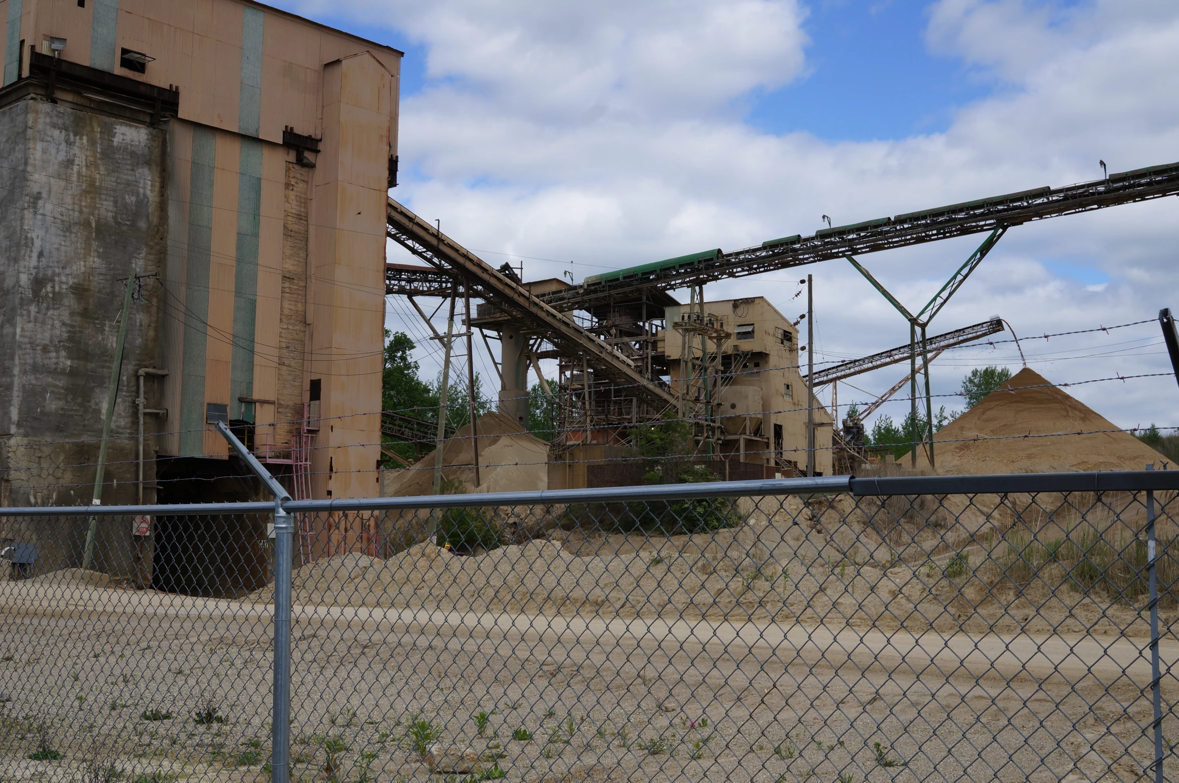 a large conveyor belt behind a chain link fence