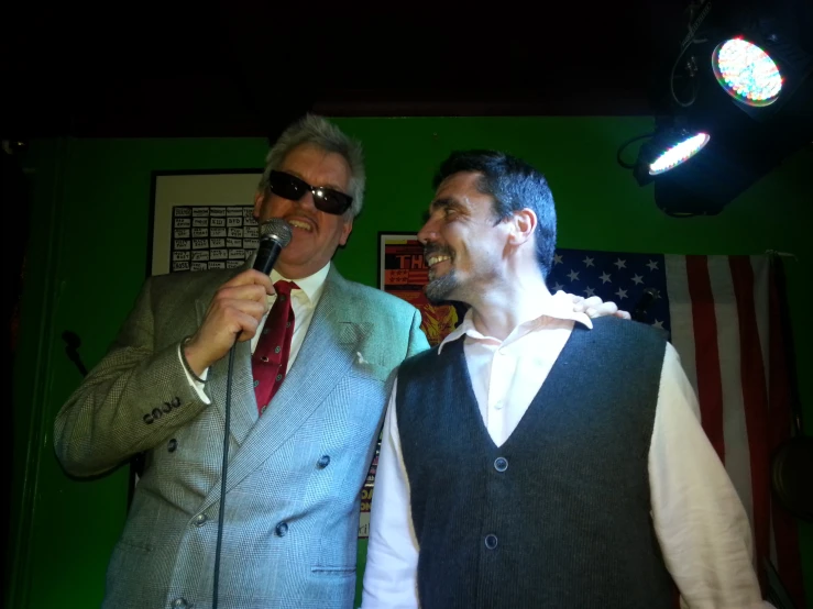 two men dressed in suits with microphones