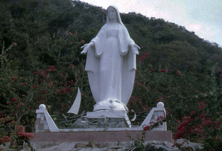 statue made of frosted white stone in front of green hills