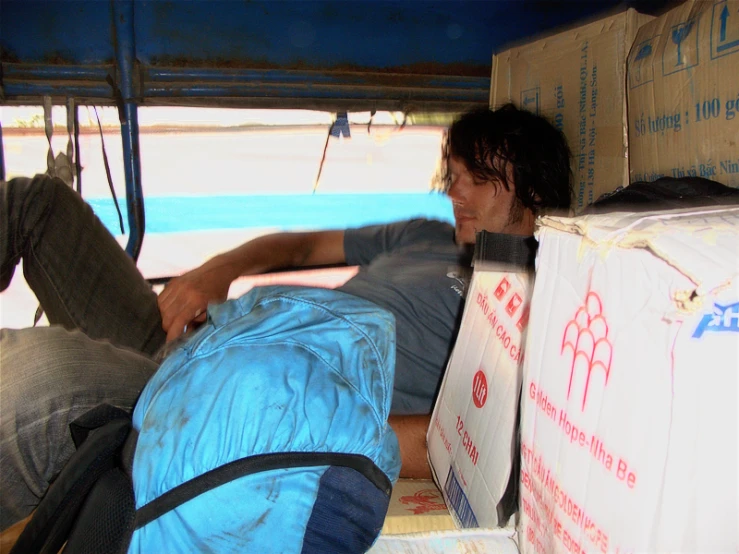 a man is sleeping on the back of a truck