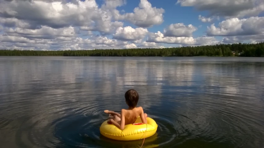 a person sitting in a body of water on an inner tube