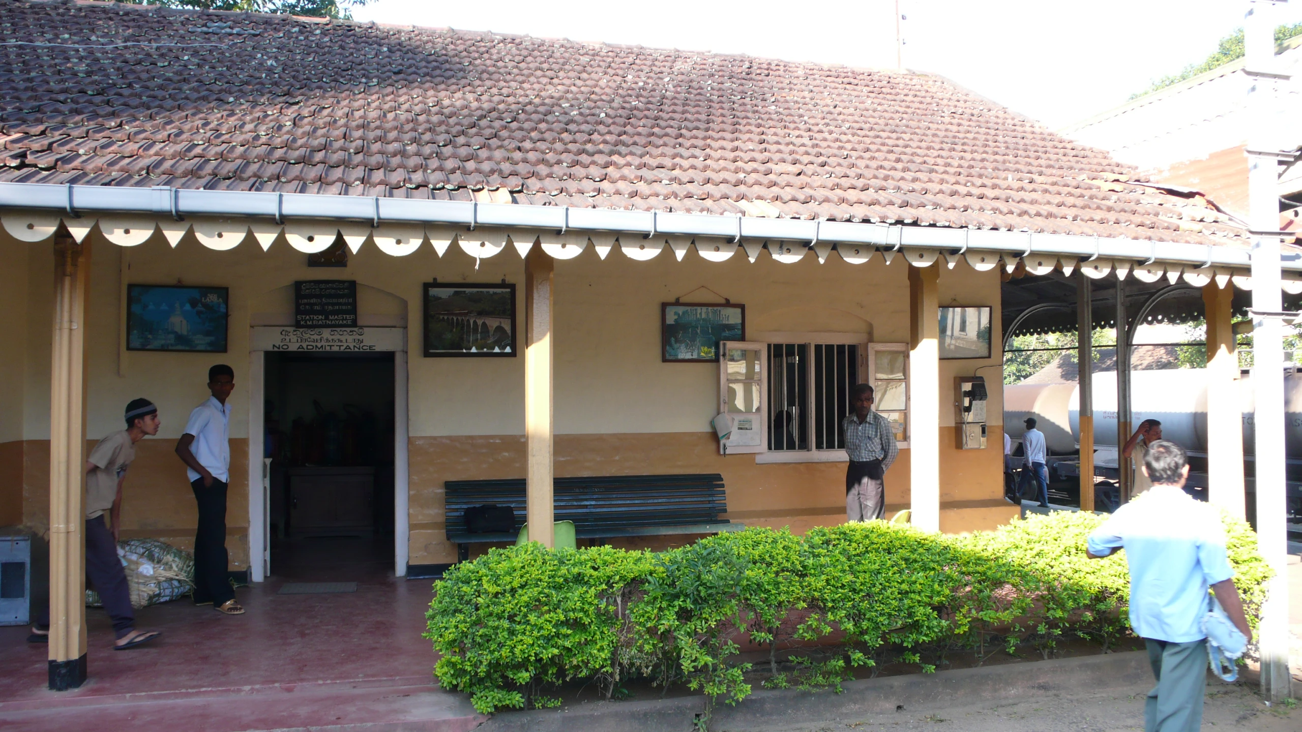 a man is walking past a building with a tile roof