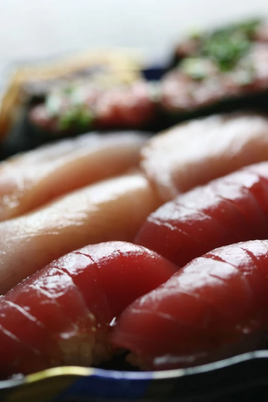 a group of sliced fish sit on plates