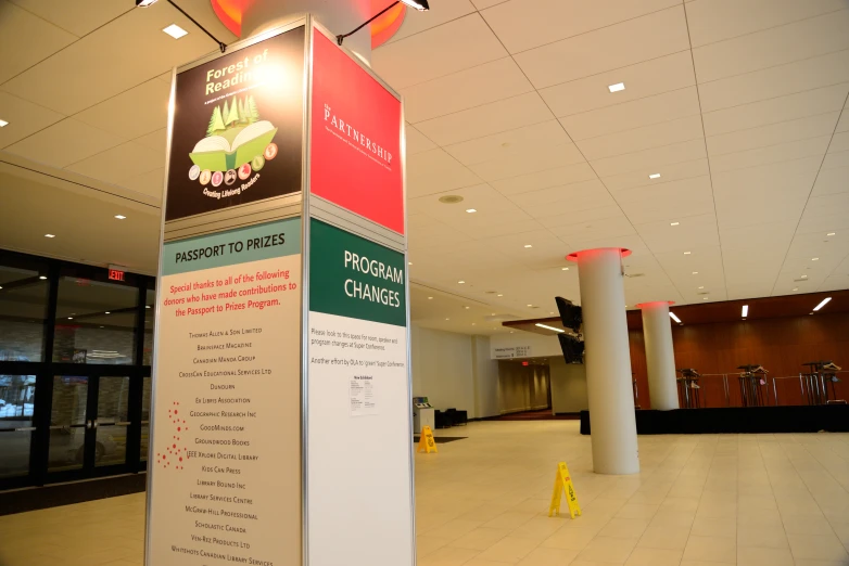 a sign sits inside a building by some pillars