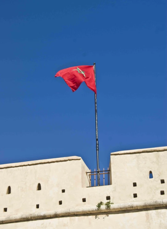 a flag flies above a tower of an old building