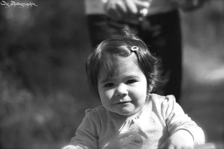 a baby girl wearing a striped shirt smiling