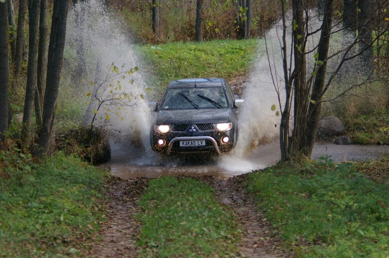 a car driving through a dle in the mud