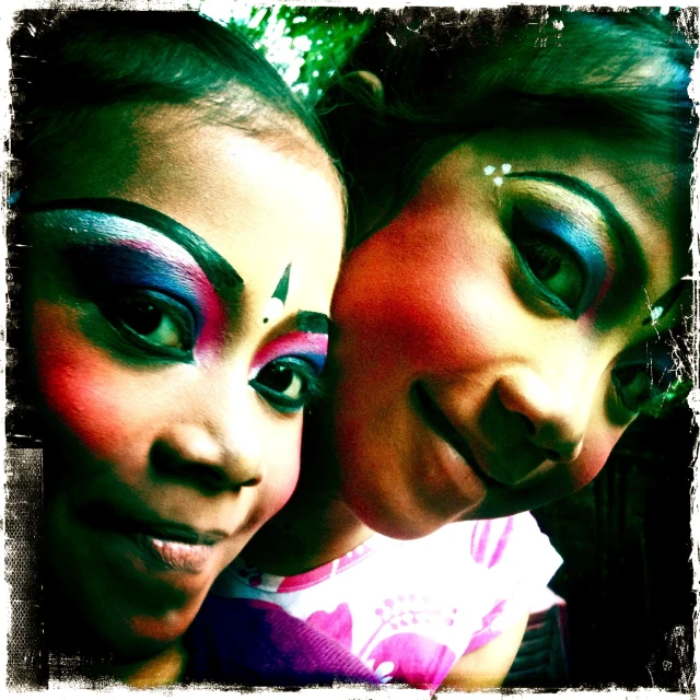 two women with colorful makeup and make - up