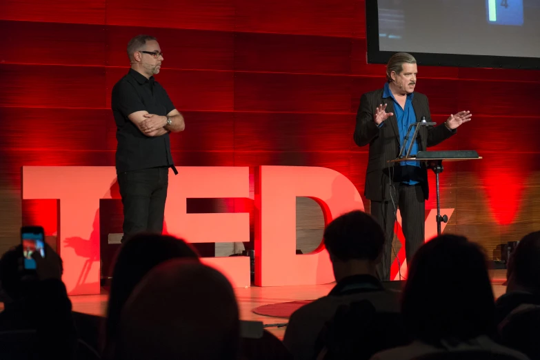 two men in front of a podium on a stage