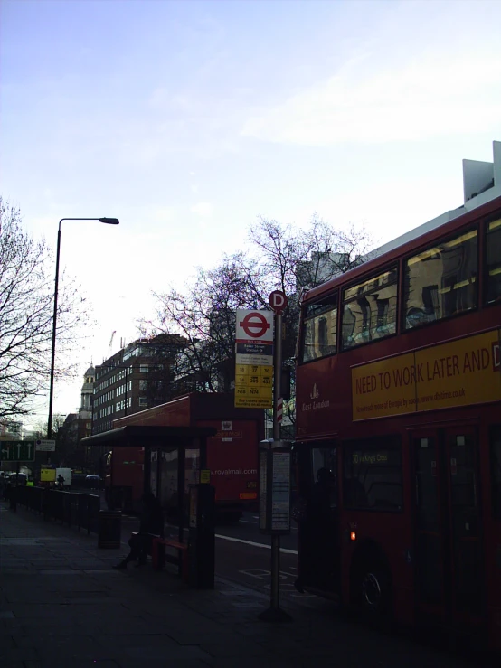 a large double decker bus is stopped at the side of the street