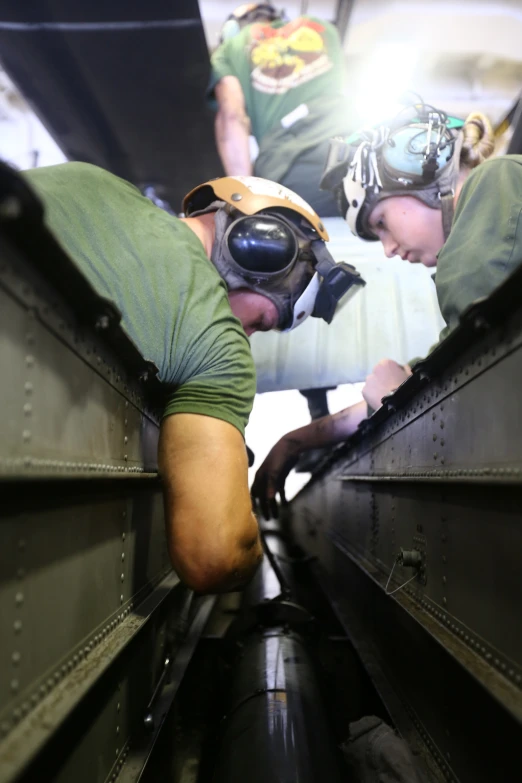 two men working on soing inside of an airplane