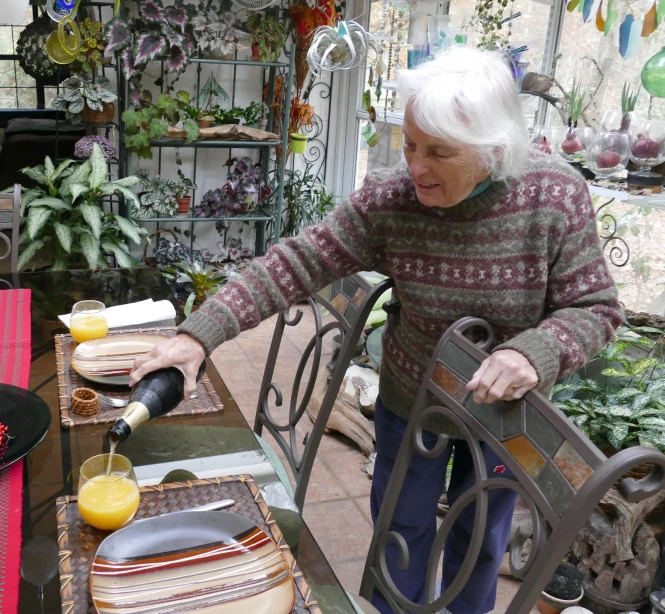 an elderly woman preparing food at a patio table