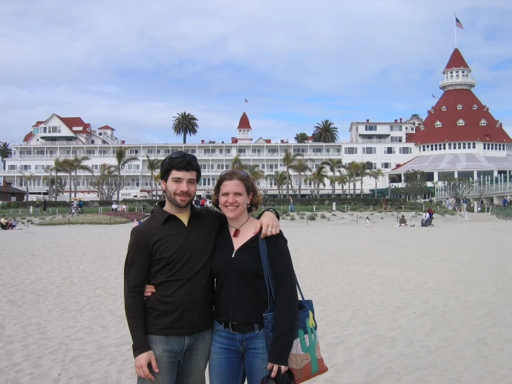 a man and woman are standing on a beach