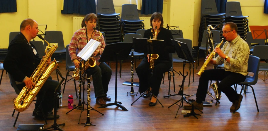 three men playing instruments in a orchestra with a band behind them