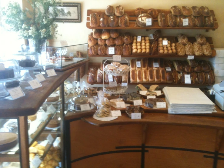 several shelves with different kinds of breads and pastries