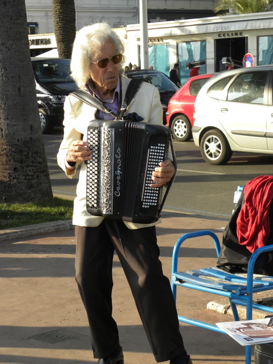 a man wearing a white shirt and black pants with an accordion in his hands