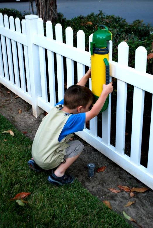 boy playing with yellow and green water hydrant