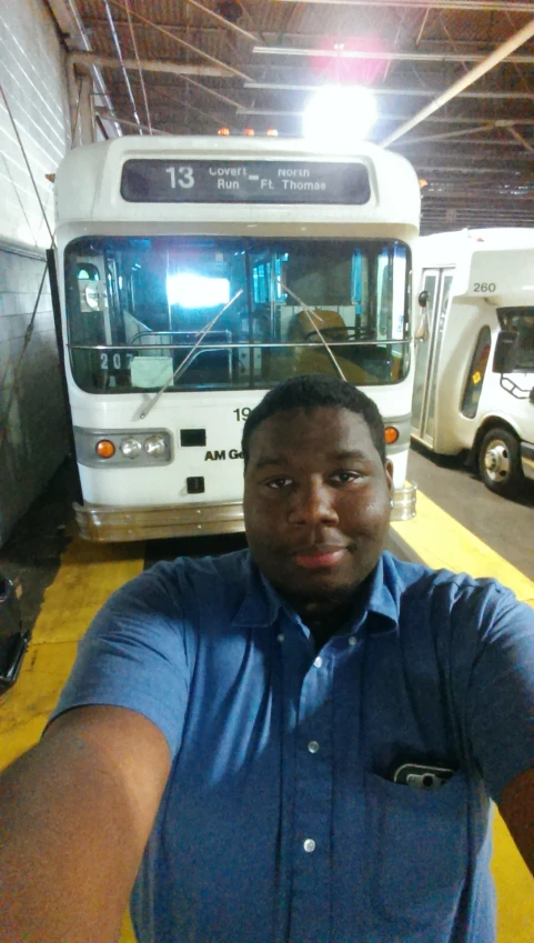 a man standing in front of a white bus