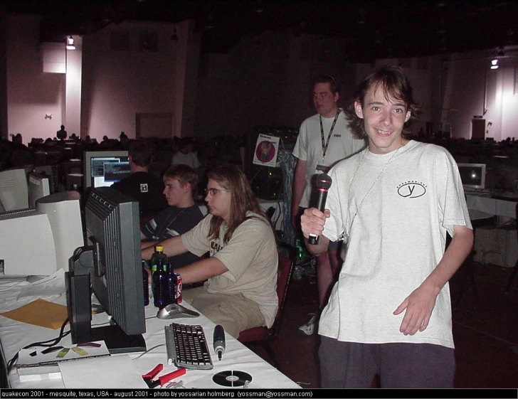 young people are playing video games while a group of other people look on