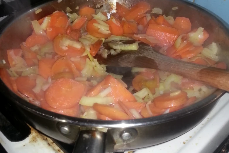 the carrots are being cooked in a pot on the stove