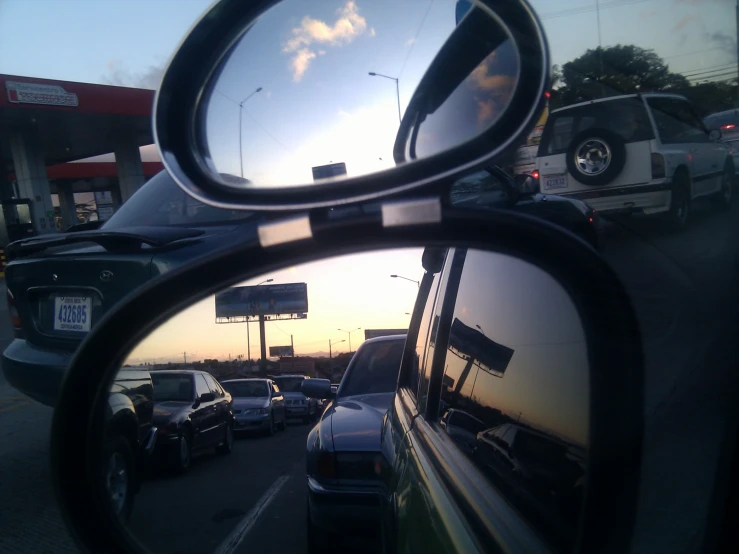 a car's view in the mirror of a cars parked on the side of the road