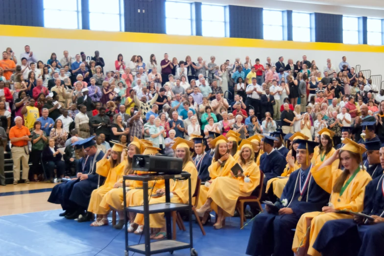 graduation students sitting in rows in front of an audience