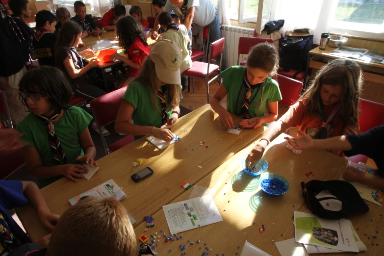 several children seated at the table doing crafts together